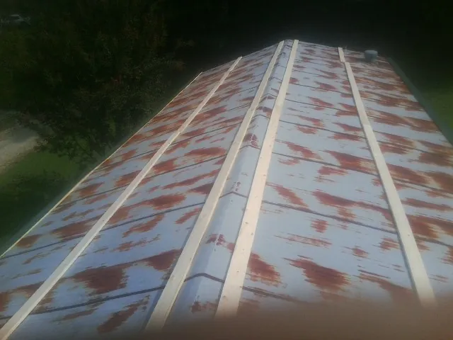 Rusted metal roof panels with new wood purlins before replacement — Storm Damage Roof Repair in Lorton by Roofing Brothers