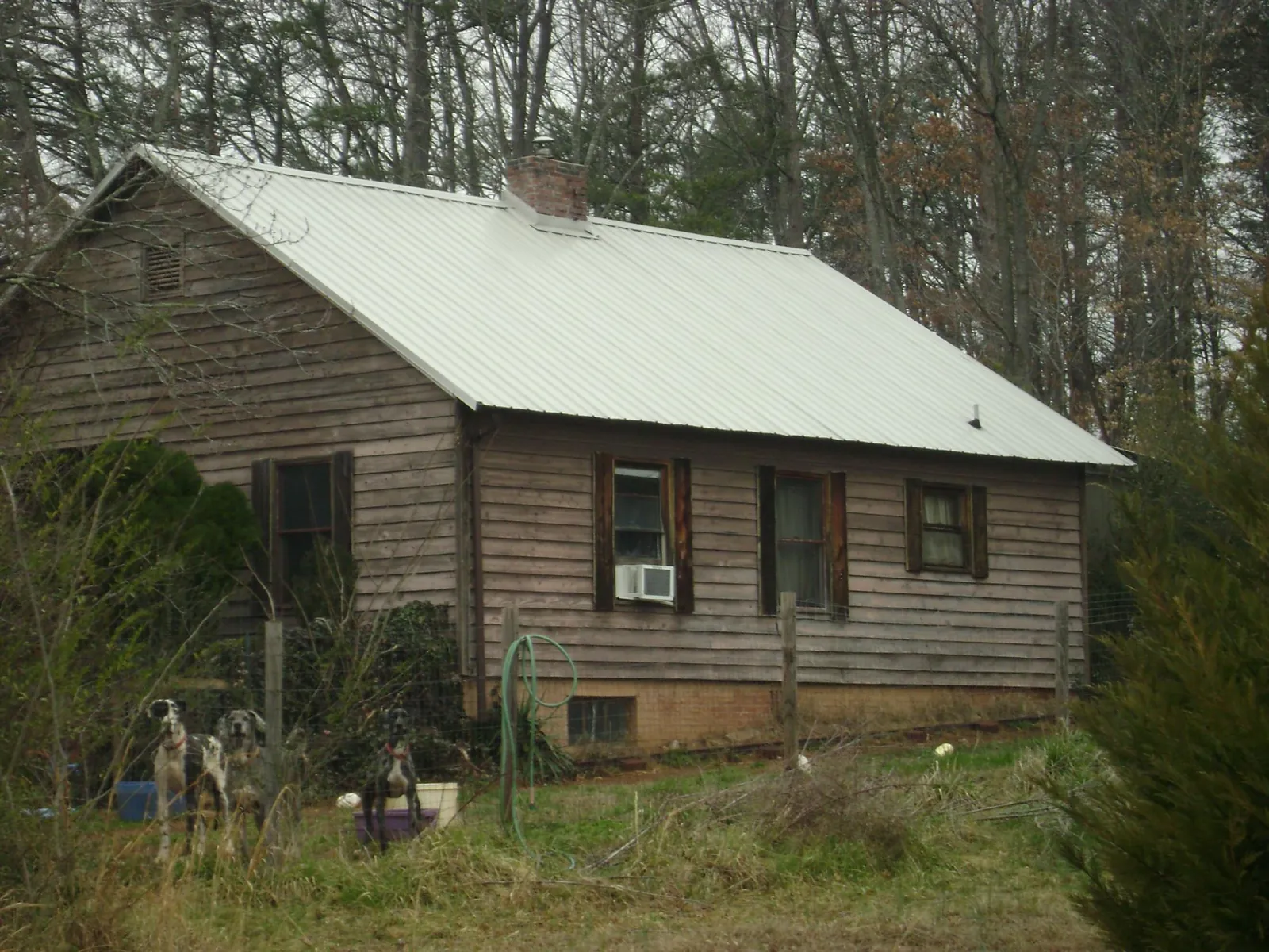 White metal roof on an old wood sided farmhouse, from a Asphalt Shingle Roof Repair job in Lorton